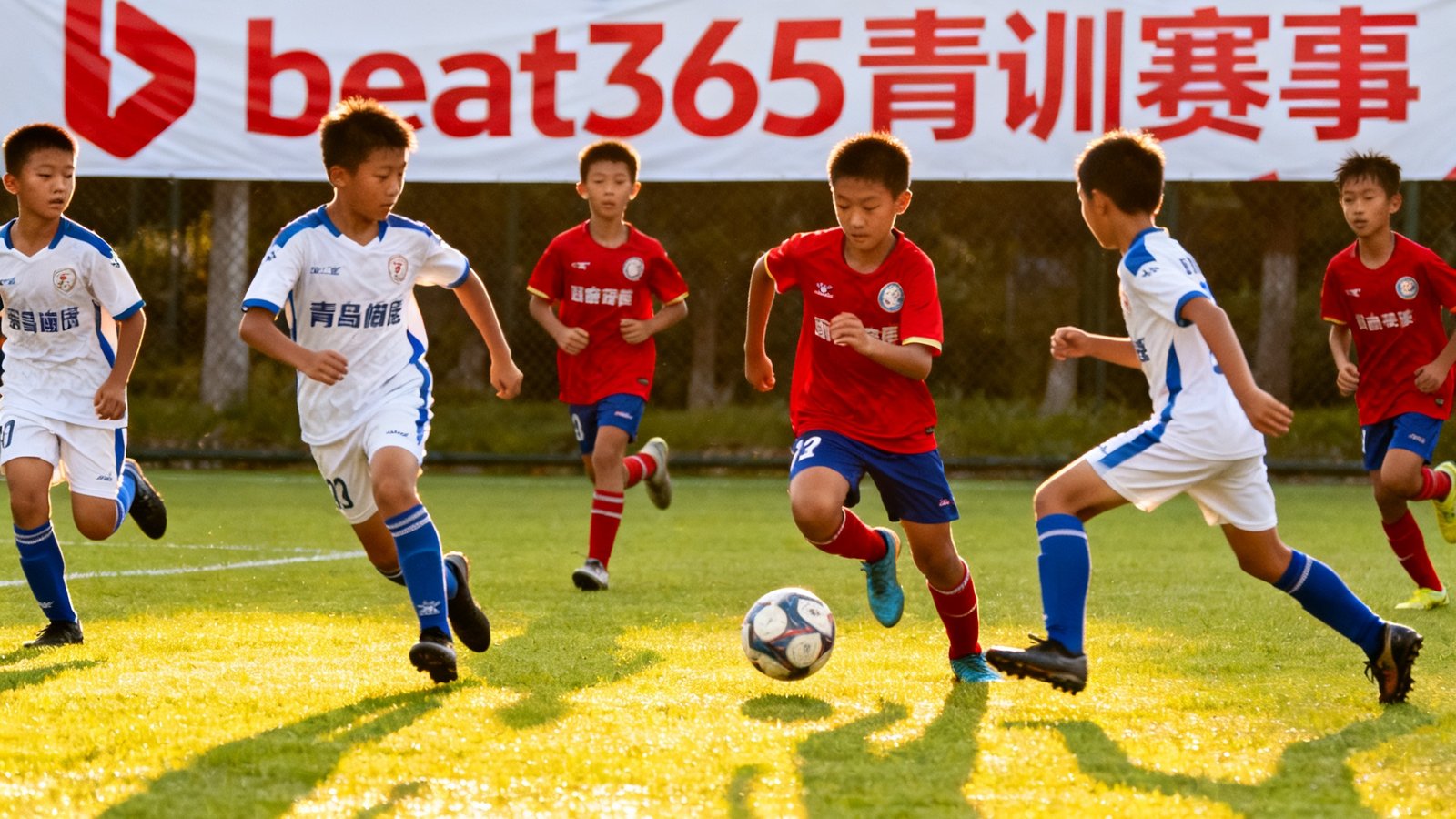 阳光明媚的绿茵场上，两支青少年足球队激烈拼抢，场边悬挂beat365赛事横幅，体现青训赛事运营